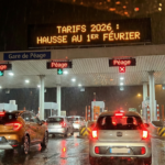 Barrière de péage autoroutier de nuit sous la pluie avec affichage tarifaire lumineux - Hausse tarifs 2026